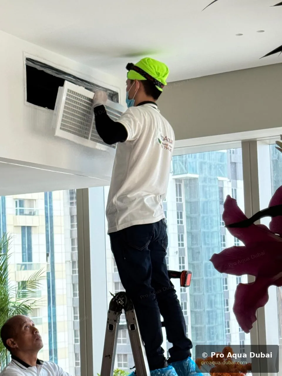 Pro Aqua technician working on AC duct grille